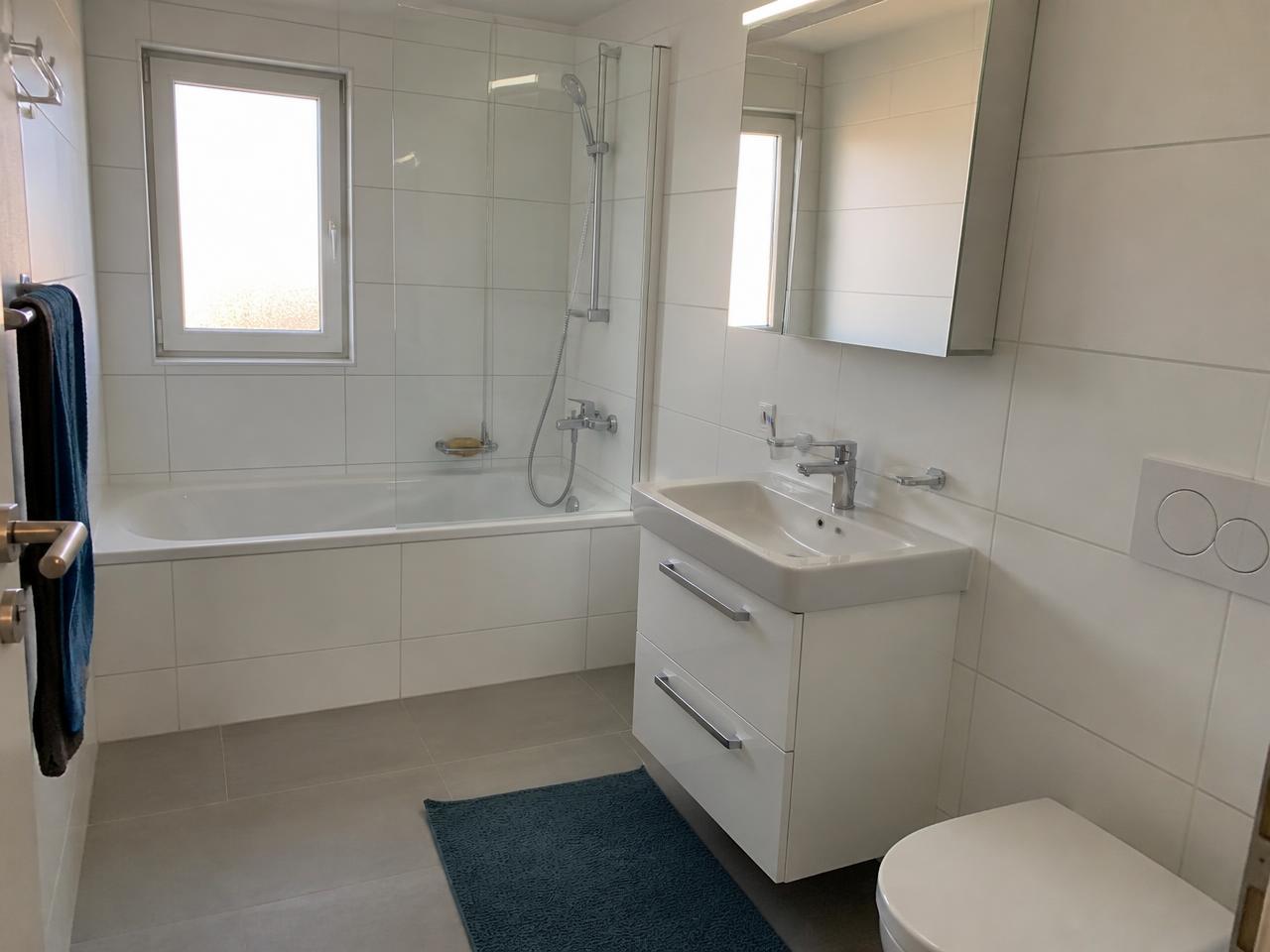 Saniertes Familienbad mit Badewanne, Duschtrennwand und Spiegelschrank